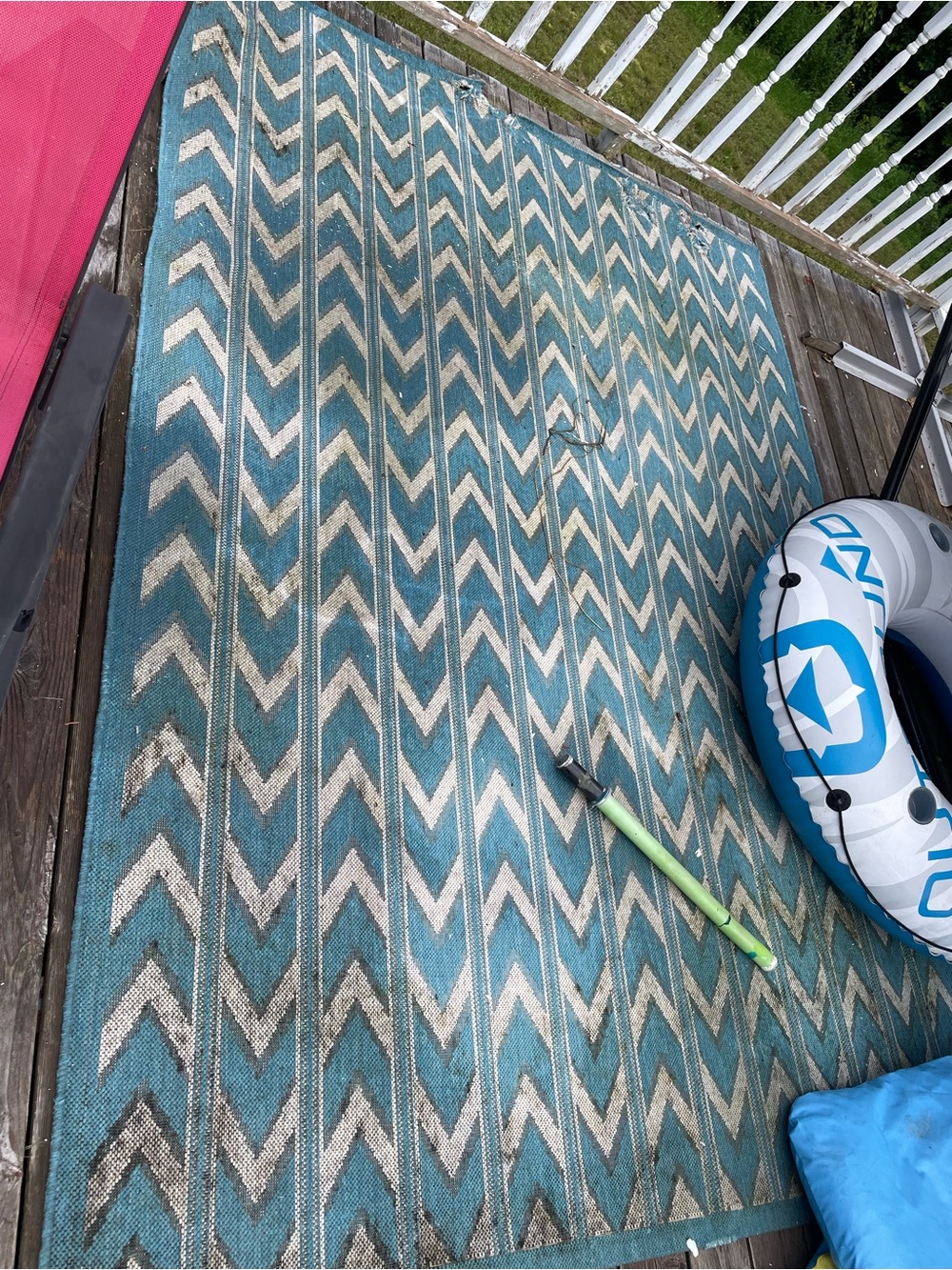 Outdoor Chevron-Pattern Area Rug - Teal and Cream frayed at one end and stained